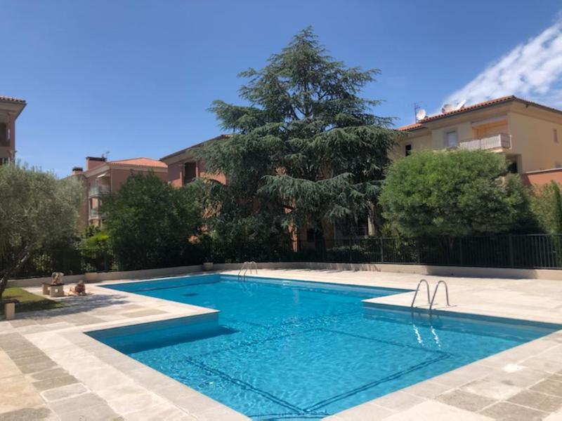 une piscine avec de l'eau bleue devant un immeuble dans l'établissement Belle résidence au centre de Saint Tropez avec piscine et garage, à Saint-Tropez