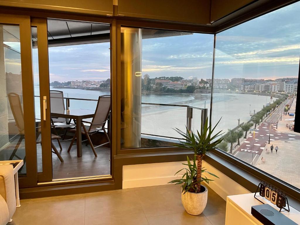 a room with a large window with a view of the water at Luxury boutique playa Silgar in Sanxenxo