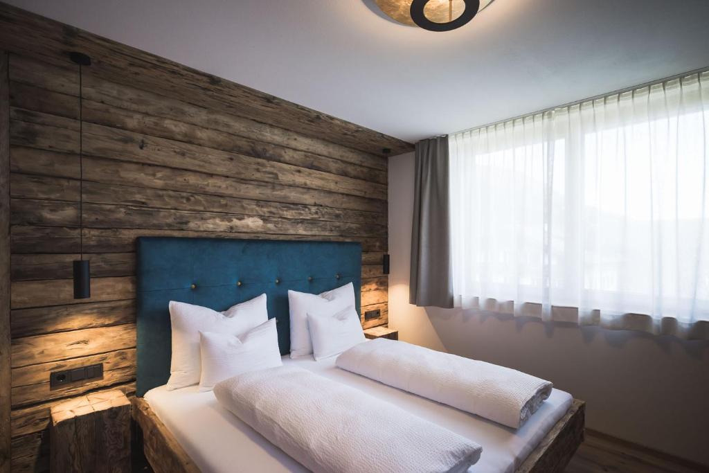 um quarto com uma cama e uma parede de madeira em Schuischta Mountain Apartments em Sesto
