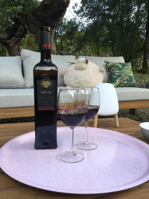 Una botella de vino y dos copas en una mesa. en Villa Bleucassis, en Taradeau