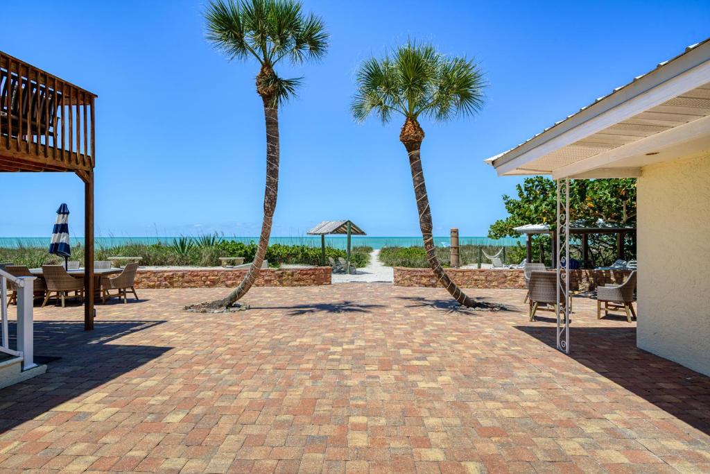 a patio with palm trees and the ocean in the background at Suntan Terrace in Nokomis