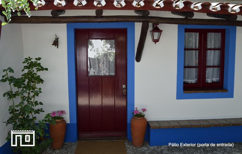 una casa con una puerta roja y una ventana en Casinha de Montoito, en Montoito