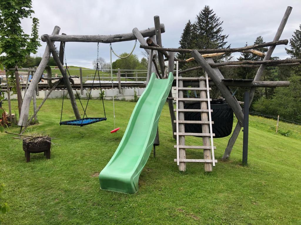 un parque infantil con un tobogán verde y una escalera en Ostallgäu, en Ruderatshofen