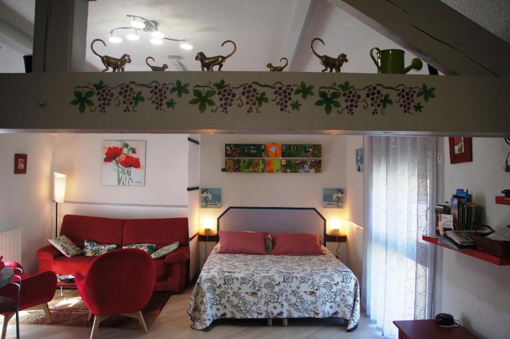 ein Schlafzimmer mit einem Bett und einem roten Stuhl in der Unterkunft Le Logis du Vendangeur in Champillon