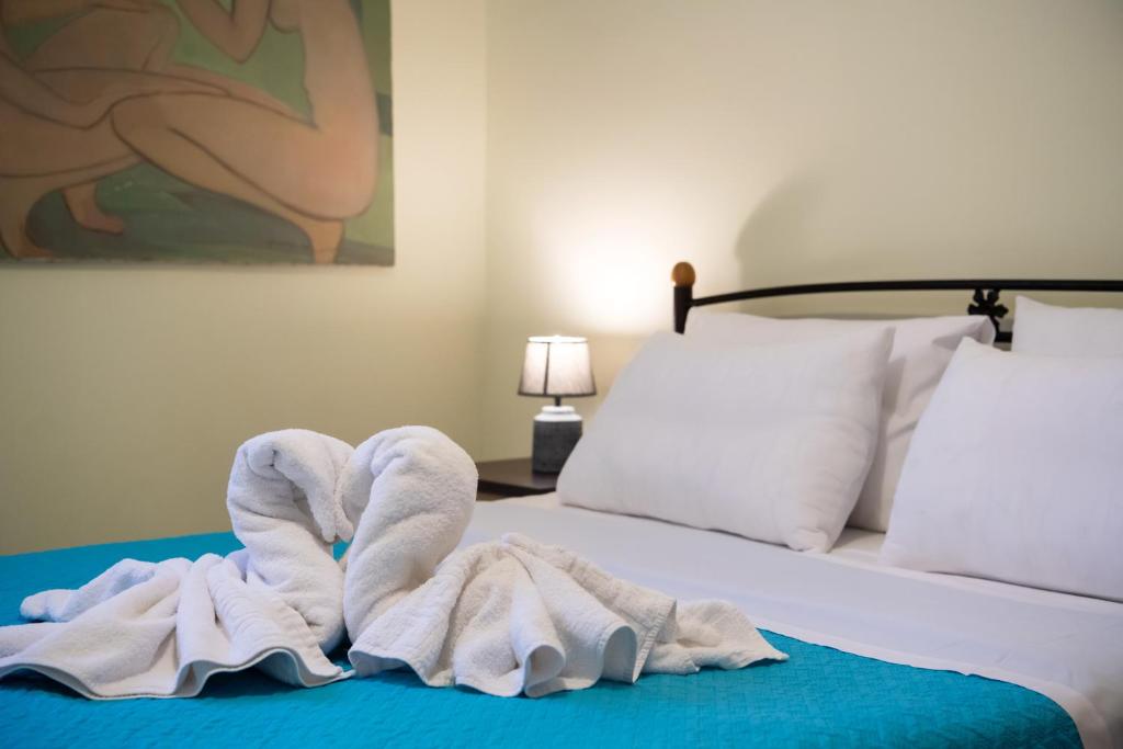 a bed with a pile of towels on it at Delphinus Villa Nefeli in Agios Nikitas