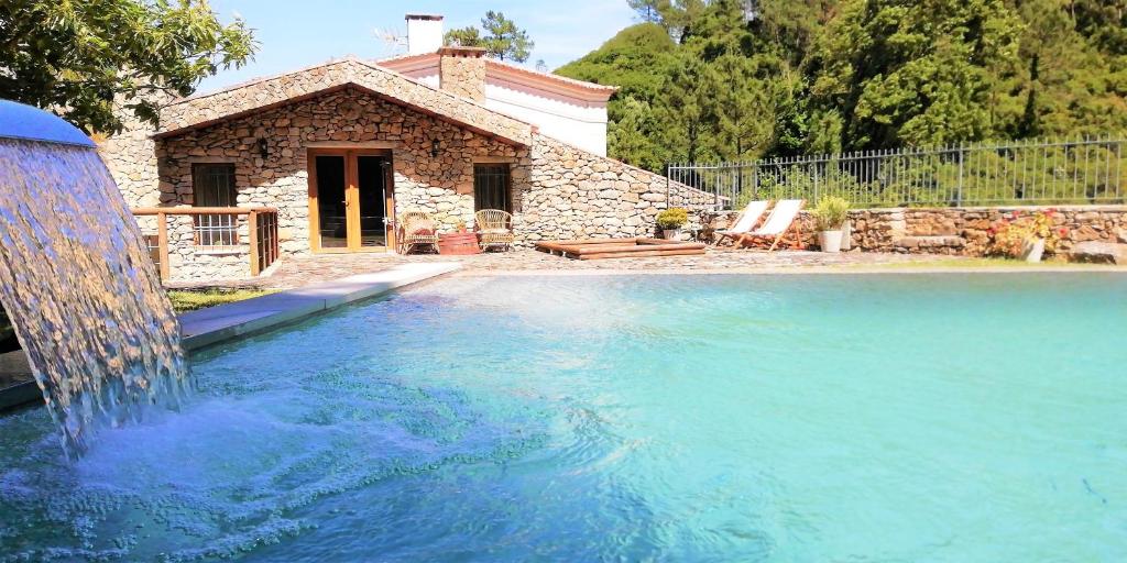 a swimming pool with a water fountain in front of a house at Rio d'Azenha - Country House in Roliça
