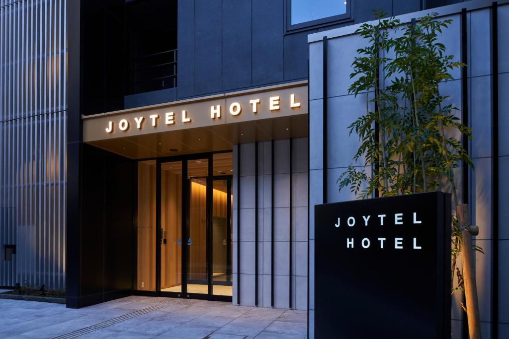 大阪市にあるジョイテルホテルなんば道頓堀の建物の前にあるjQueryのホテルの看板