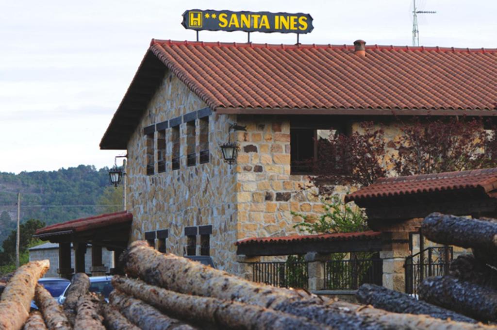 a building with a pile of logs in front of it at Hotel Santa Inés in Vinuesa