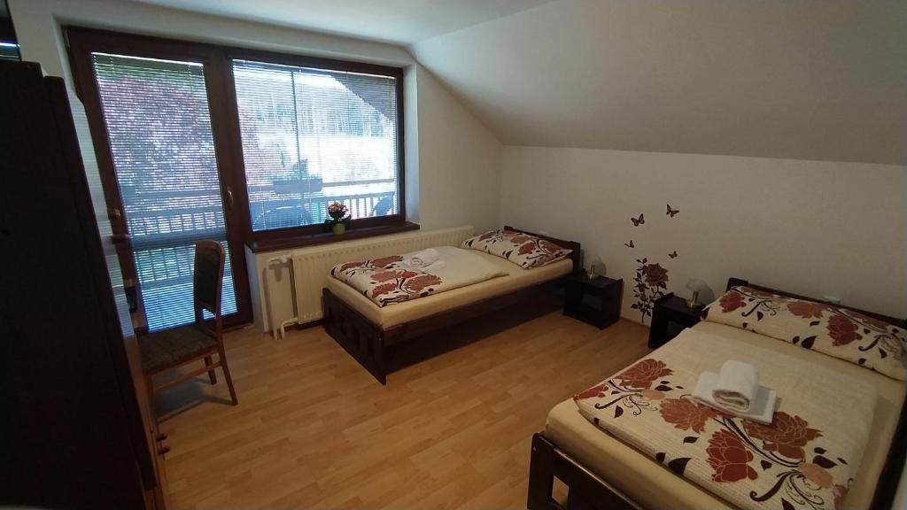 a small bedroom with two beds and a window at Apartmán U Špýcharu in Bílé Poličany