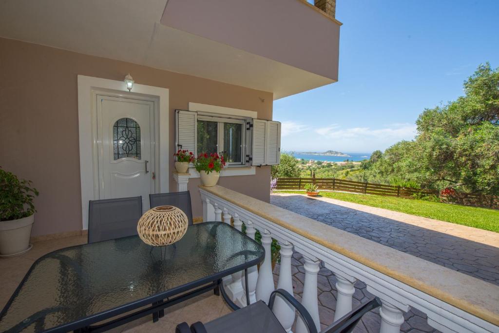 a balcony of a house with a table and chairs at Nicoles Houses Arillas Corfu in Arillas