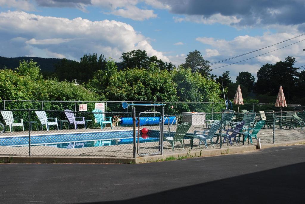 a group of chairs sitting next to a swimming pool at The Austin Inn in Lake George