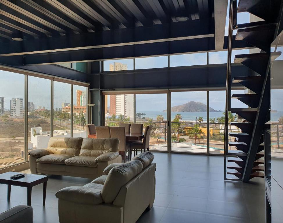 una sala de estar con sofás y una escalera de caracol en Manzara Resort en Mazatlán