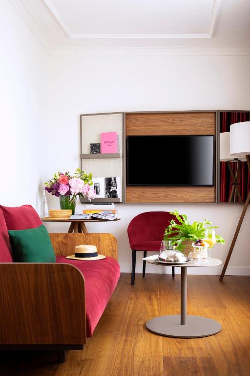 a living room with a red couch and a tv at Villa Marquis Member of Meliá Collection in Paris