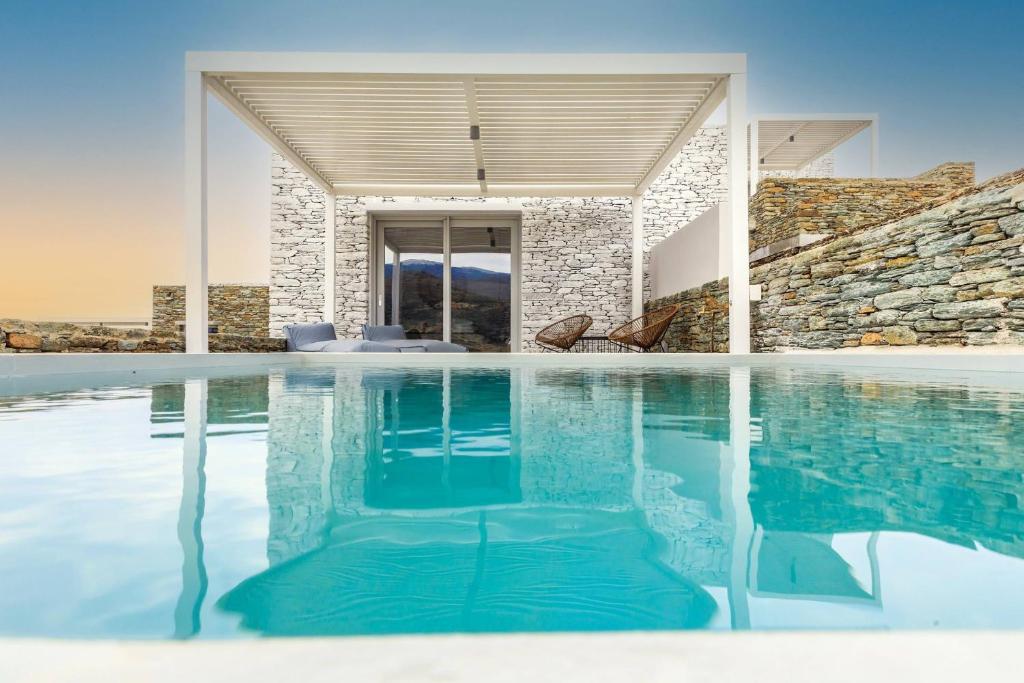 a swimming pool in a house with a stone wall at Iliades Luxury Boutique Suites in Batsi