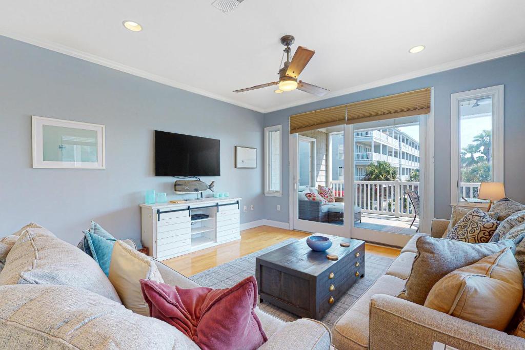 uma sala de estar com um sofá e uma TV em Cool Corner em Folly Beach