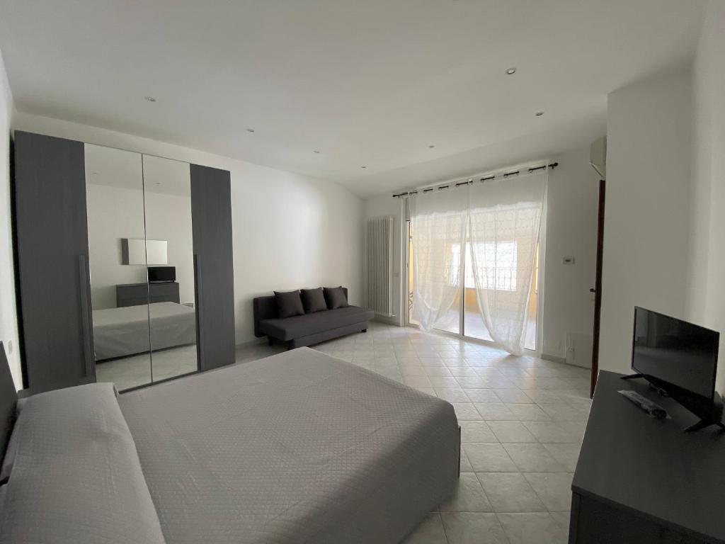 1 dormitorio con cama, sofá y TV en U Carùggiu, en Villanova dʼAlbenga