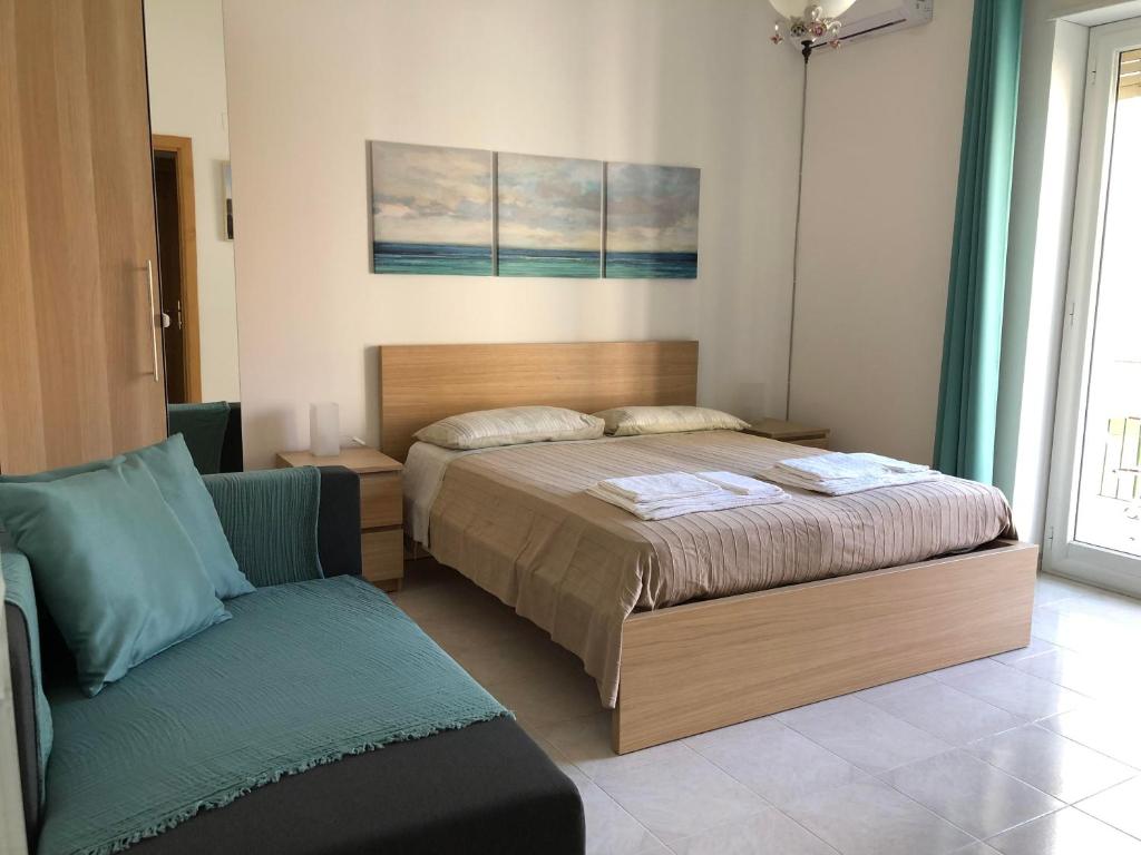 a bedroom with a bed and a couch in it at Gaeta Holidays in Gaeta