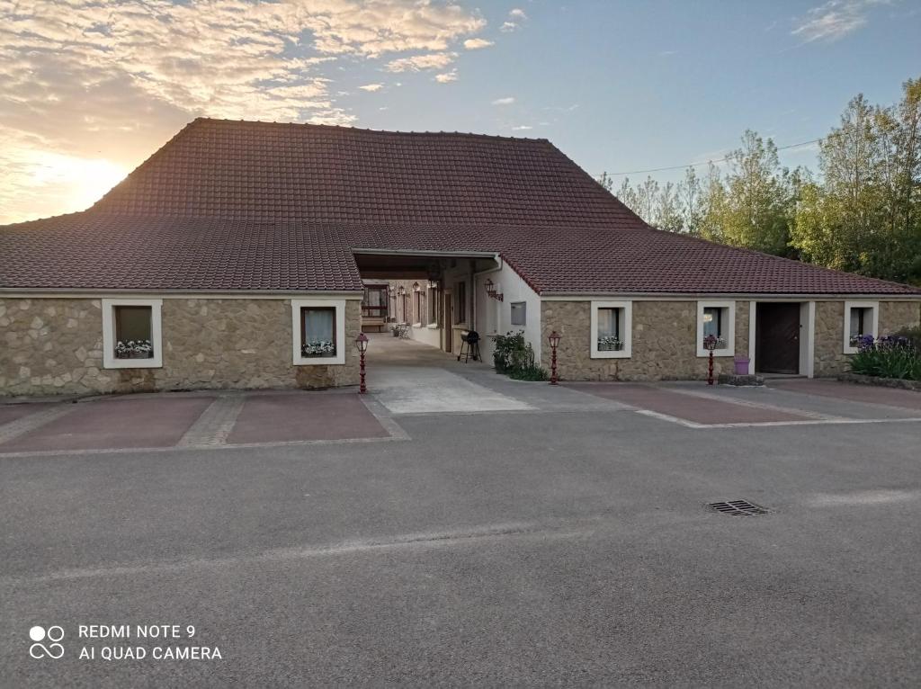 un edificio con un techo grande en un aparcamiento en La ferme du guindal en Marquise