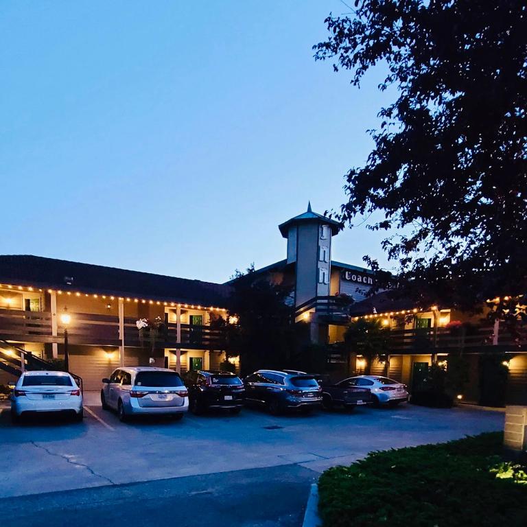 a group of cars parked in a parking lot in front of a hotel at Coachman Inn Oak Harbor in Oak Harbor
