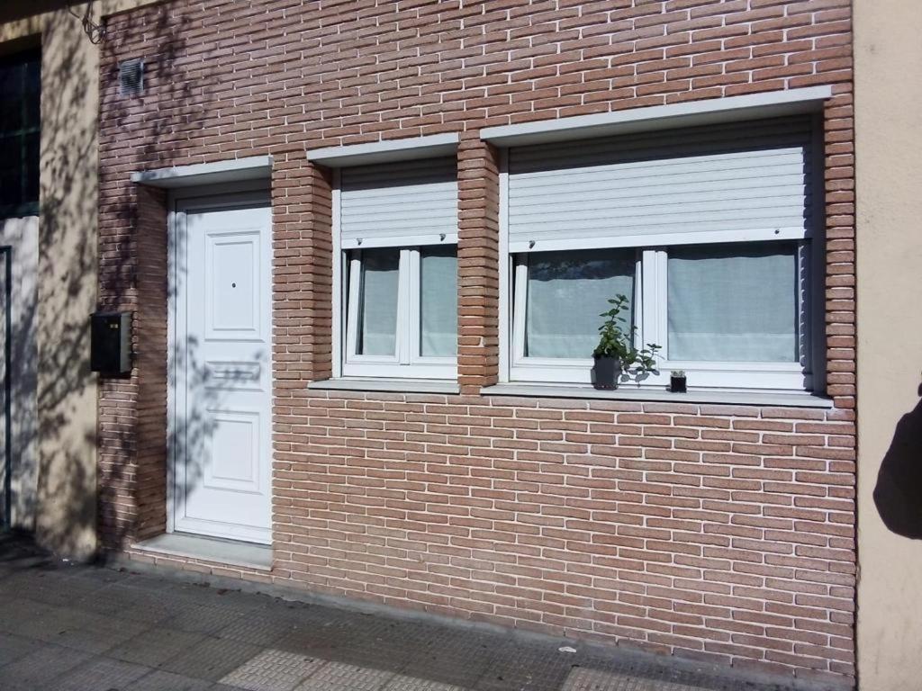 a brick building with two windows and a potted plant at UGARTEKO ETXEA in Llodio