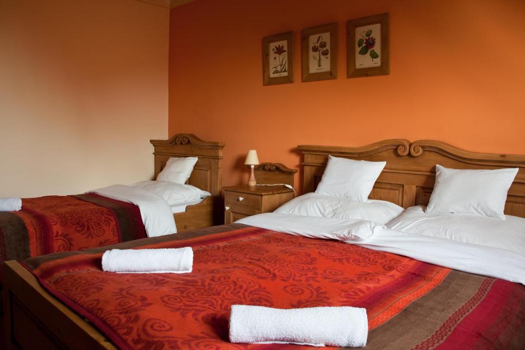 a hotel room with two beds with white pillows at St.Michael Panzió Lovaspark in Vasszentmihály