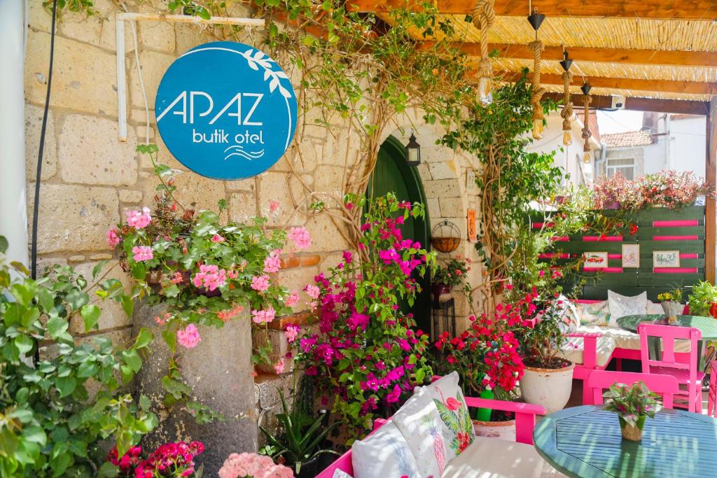 a sign for a flower shop with pink chairs and flowers at Apaz Alaçatı Hotel in Alaçatı