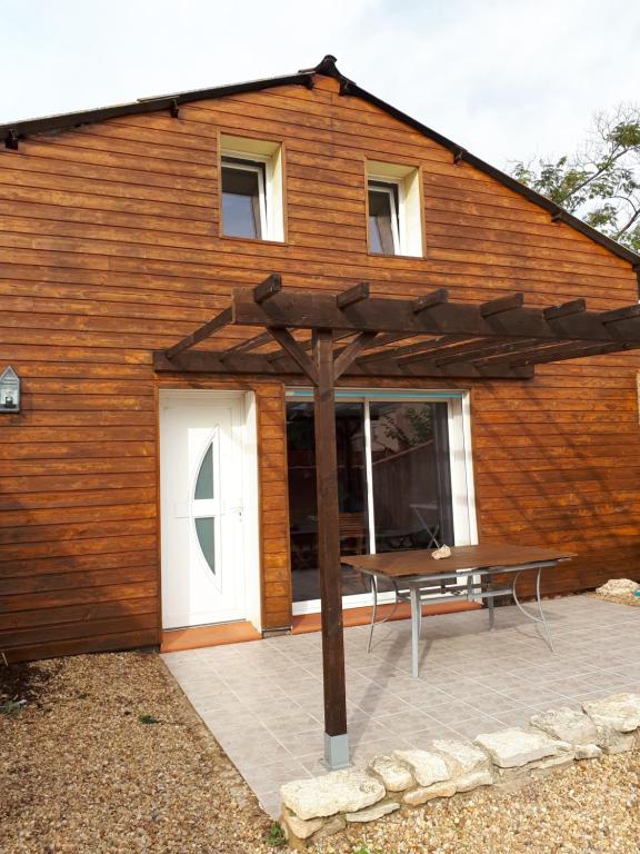 - un bâtiment en bois avec une table de pique-nique devant dans l'établissement La Sigeannaise maison climatisée Wi-Fi, à Sigean