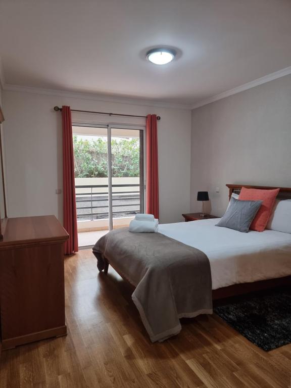 um quarto com uma cama grande e uma janela em Suncoast Residence V (Free parking) em Funchal