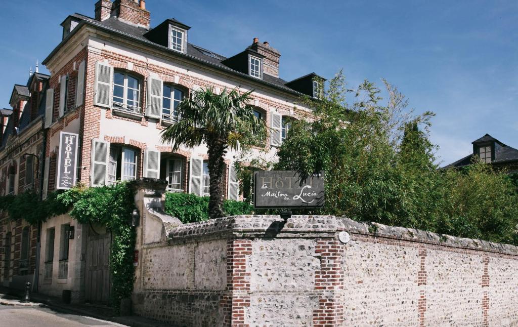 un edificio de ladrillo con un cartel en una pared de ladrillo en La Maison De Lucie en Honfleur