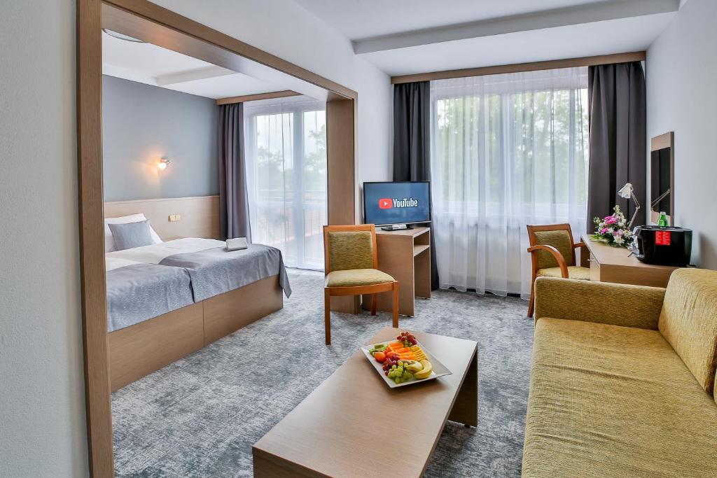 Habitación de hotel con cama y sala de estar. en LH Parkhotel Hluboka Nad Vltavou, en Hluboká nad Vltavou