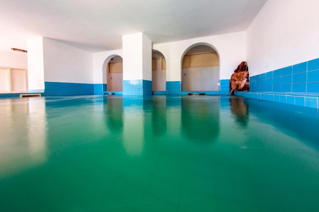 a swimming pool with blue and white walls and blue tiles at Hotel La Mandorla in Ischia