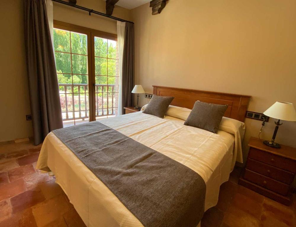 a bedroom with a large bed and a window at Hotel Rural El Lagar de Nemesio in Perales de Tajuña