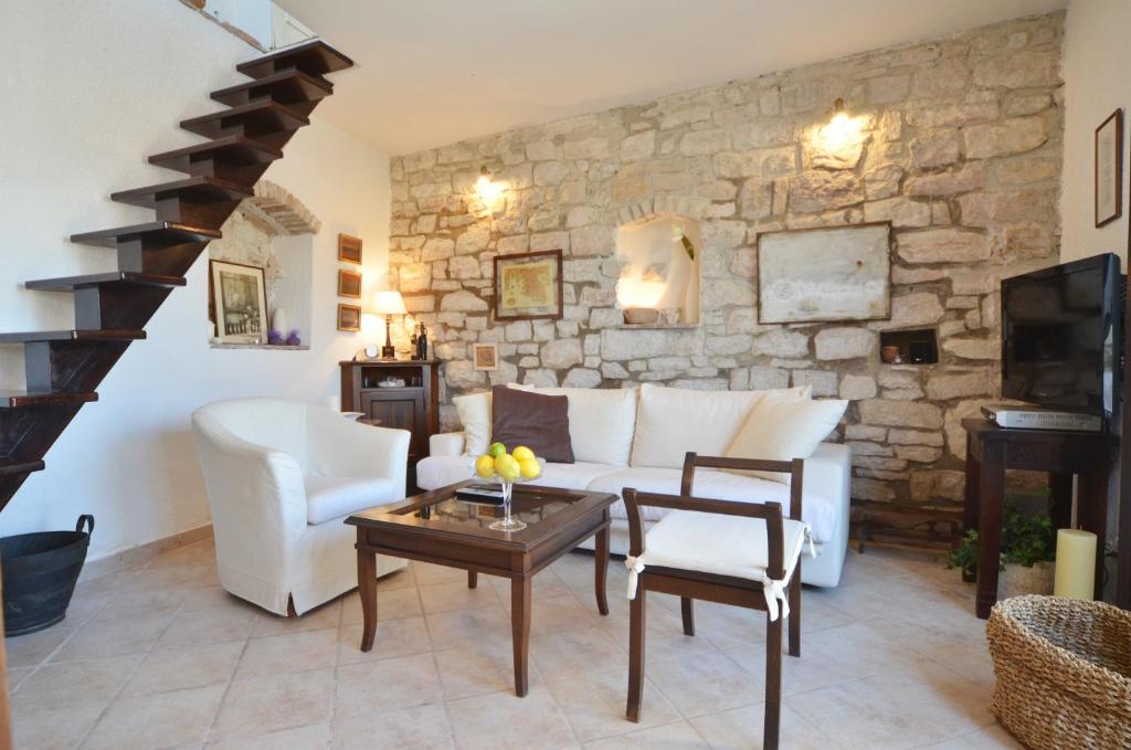sala de estar con sofá blanco y pared de piedra en Sea View House Olja, en Rovinj