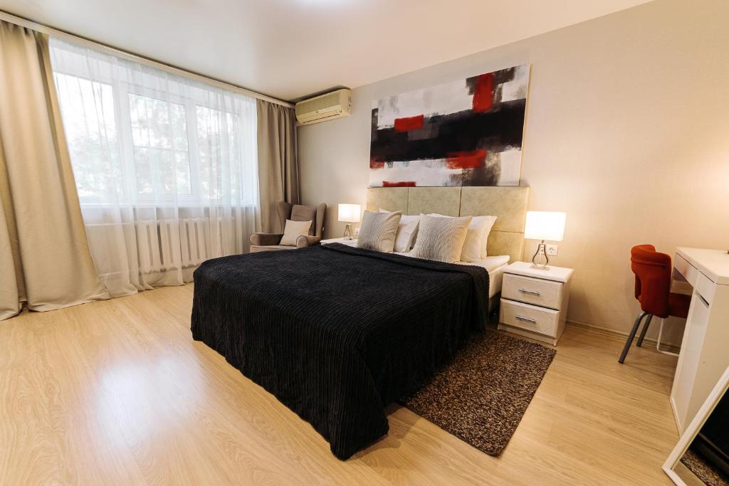 1 dormitorio con 1 cama grande con manta negra en City Apartments - Junior suite room en Smolensk