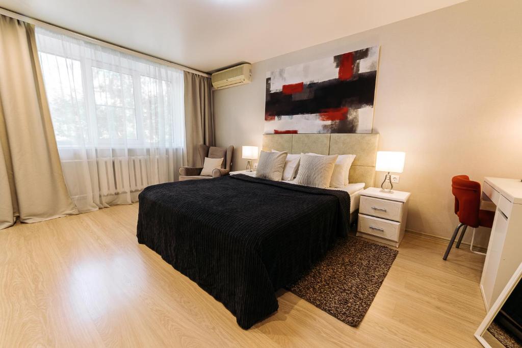 um quarto com uma cama grande e um cobertor preto em City Apartments - Junior suite room em Smolensk
