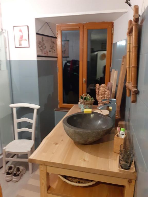 y baño con lavabo sobre una mesa de madera. en Maison authentique en pierre apparente en montagne dans le c antal en Thiézac
