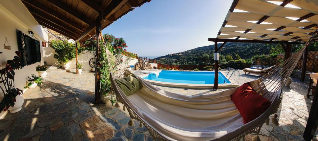 eine Hängematte auf einer Terrasse neben einem Pool in der Unterkunft Villa Braou in Rodakino