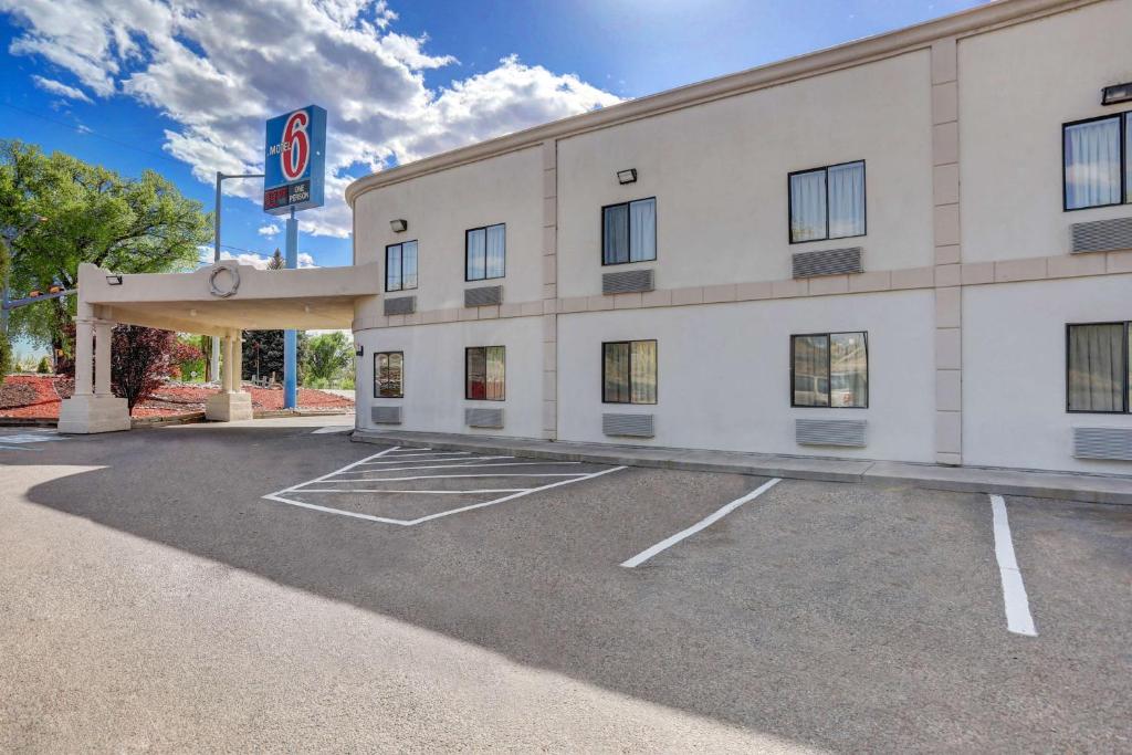 a large white building with a no parking lot at Motel 6-Espanola, NM in Espanola