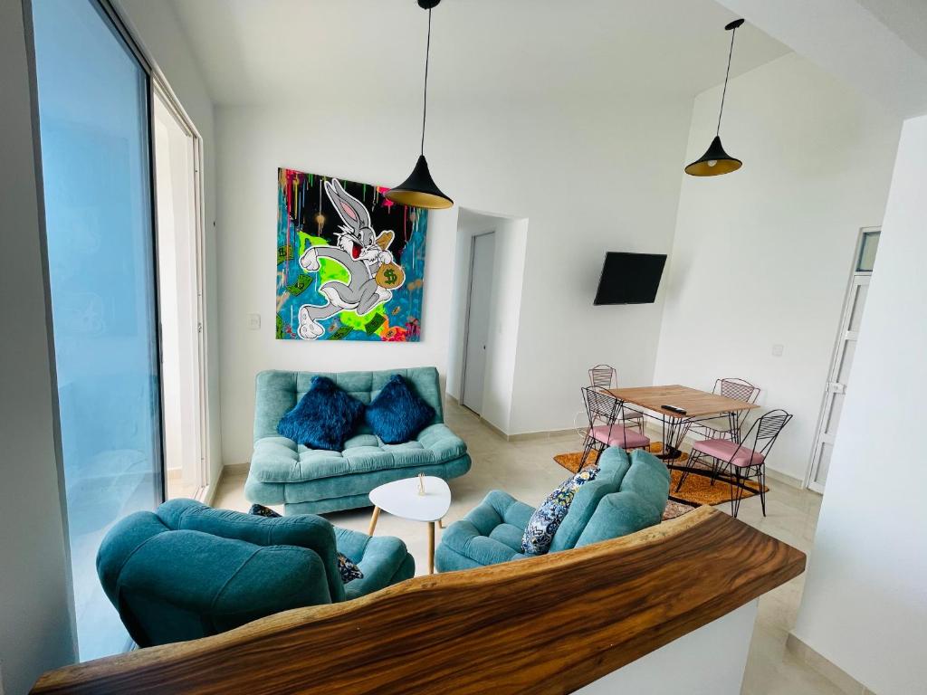een woonkamer met blauwe banken en een tafel bij Apartamento Coveñas Deluxe in Coveñas