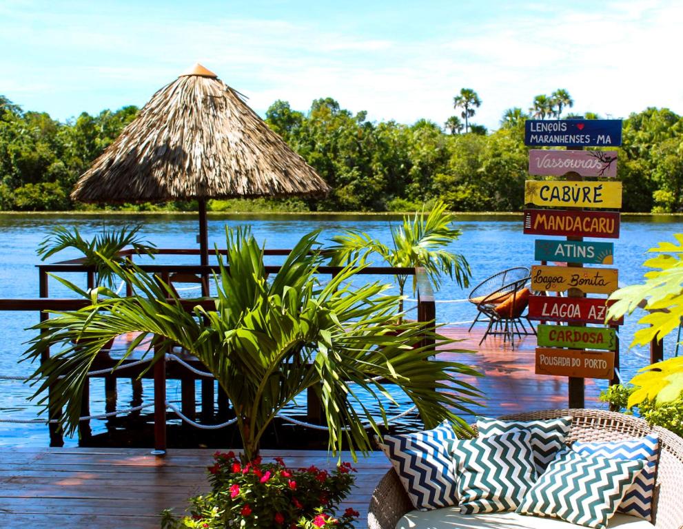 a restaurant on a dock with a table and a straw hut at Pousada Do Porto in Barreirinhas