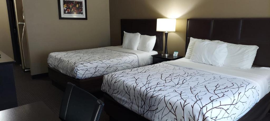 A bed or beds in a room at Parkwood Inn & Suites