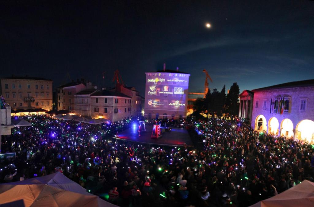 duży tłum ludzi oglądających koncert w nocy w obiekcie Apartments Antons w Puli