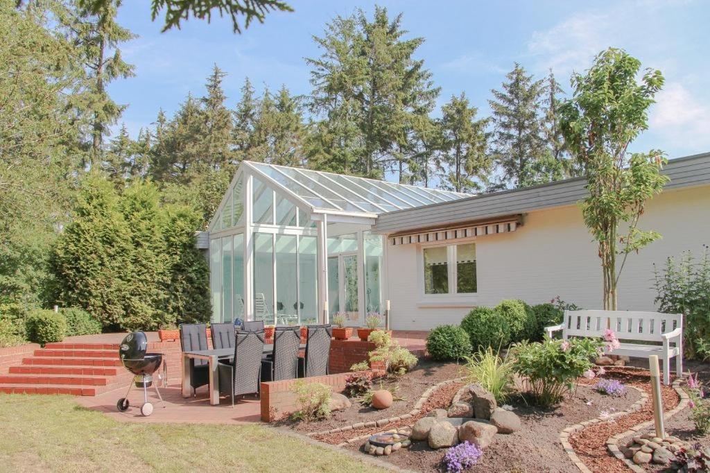 Ein Haus mit einem Glashaus mit einer Terrasse in der Unterkunft Wohlfühloase Büttjebüll in Bordelum