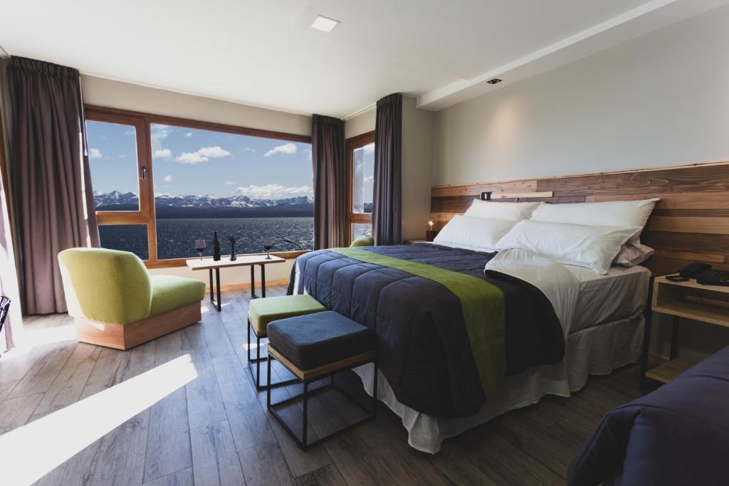 um quarto com uma cama grande e uma janela grande em Hotel Eco Max em San Carlos de Bariloche