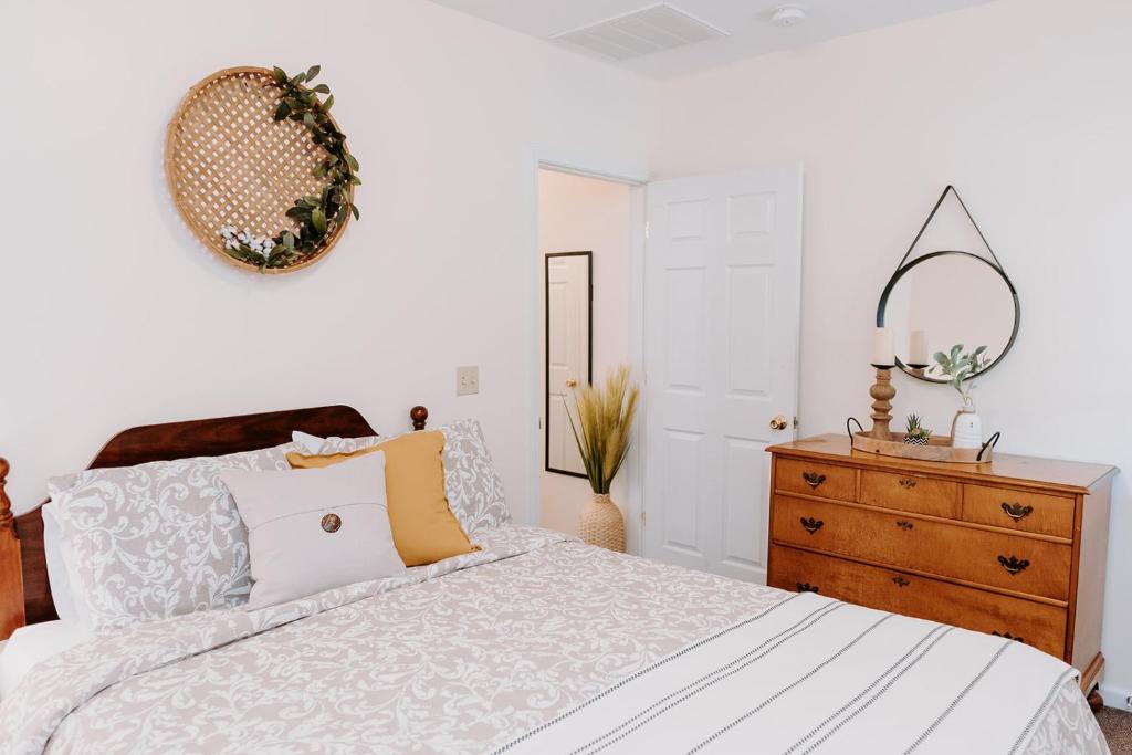 a bedroom with a bed and a dresser and a mirror at Blue Moon Motel in Lake George