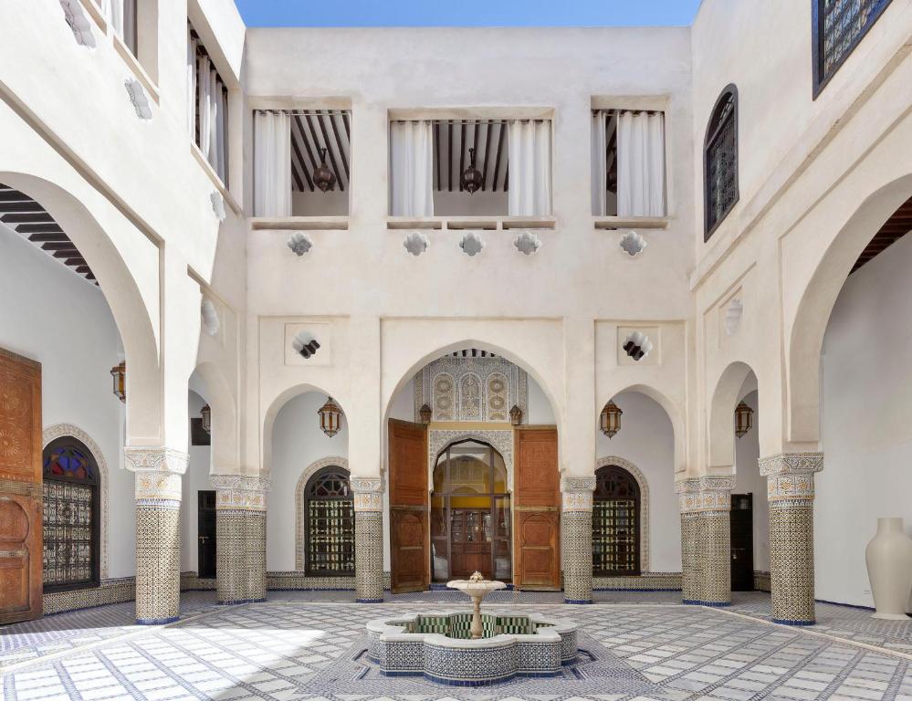 Riad Palais Bahia Fes في فاس: مبنى كبير مع ساحة مع نافورة