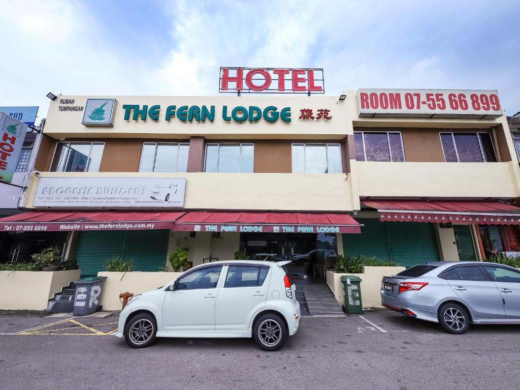 un coche blanco estacionado frente a un hotel en The Fern Lodge Hotel en Skudai