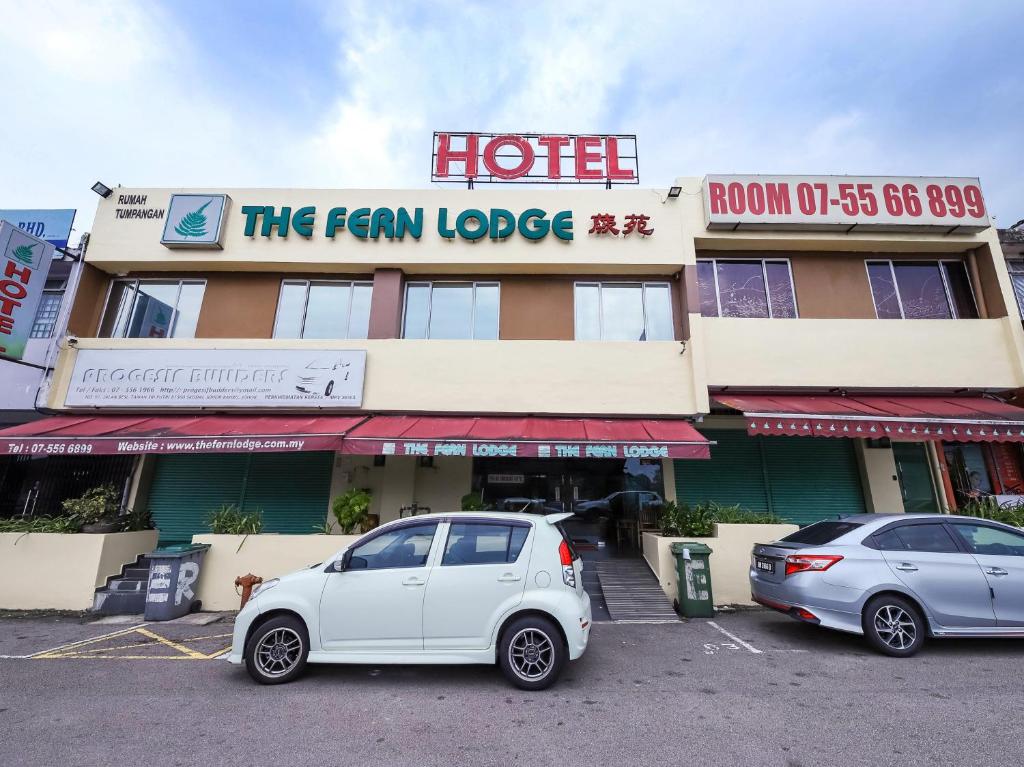 a white car parked in front of a hotel at The Fern Lodge Hotel in Skudai