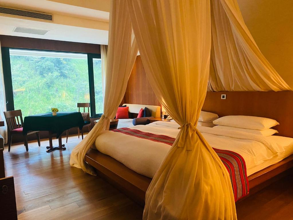 a bedroom with a bed with a mosquito net at Volando Urai Spring Spa & Resort in Wulai