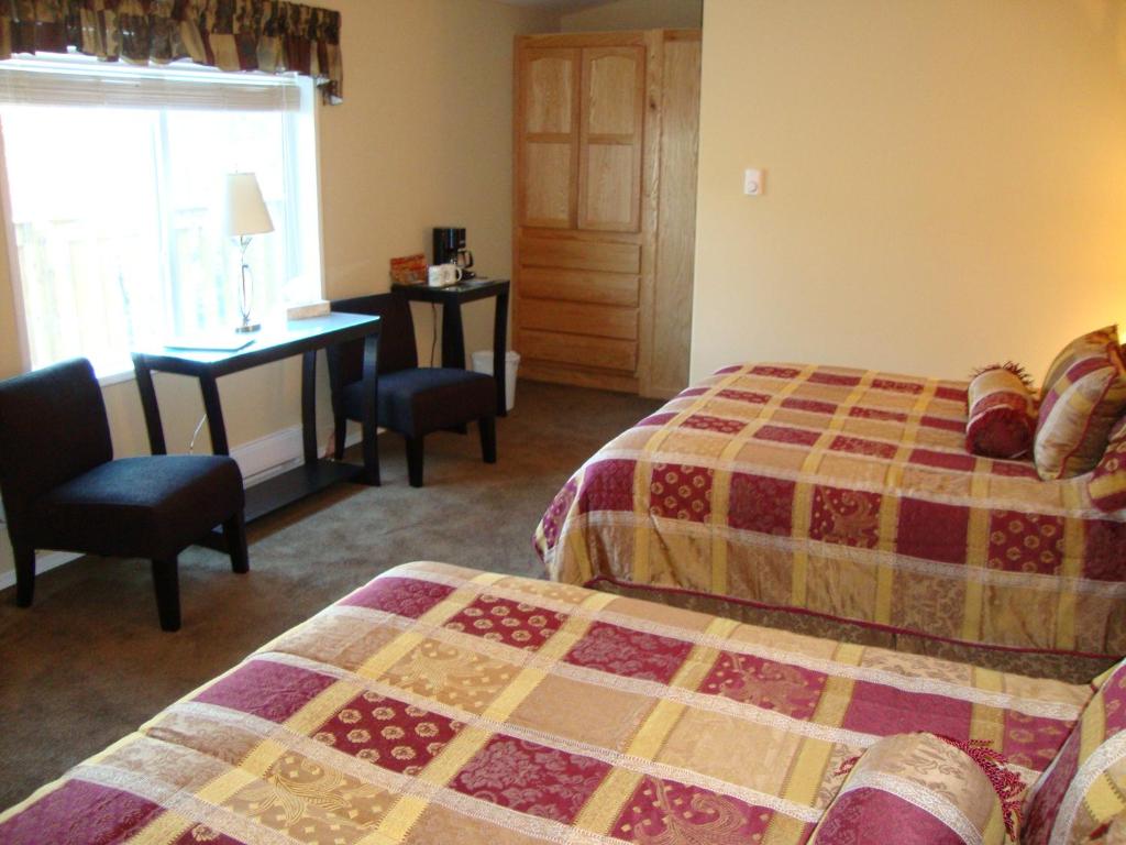 Postel nebo postele na pokoji v ubytování Helmcken Falls Lodge Cabin Rooms and RV Park